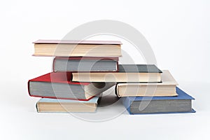 Book stack, hardback colorful books on wooden table, white background. Back to school. Copy space for text. Education business