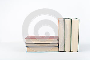 Book stack, hardback colorful books on wooden table, white background. Back to school. Copy space for text. Education business con