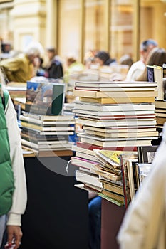 Book stacks on wood desk blurred people in bookstore, reading, hobby, second-hand books concept