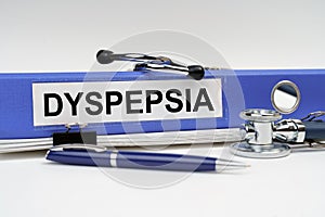 On the book is a stethoscope and a folder with the inscription - DYSPEPSIA