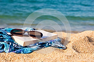 Book, sunglasses on a beach