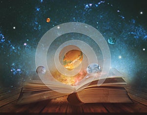 Book of the universe - opened magic book with planets and galaxies