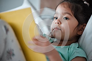 This book is very interesting. a little girl reading a book while lying on her bed.