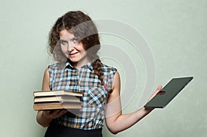 Book vs digital tablet. A woman makes a choice between books in one of her hands and digital tablet in the other