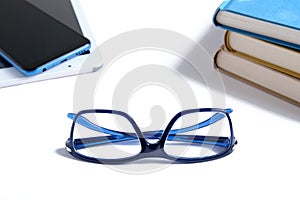 Book vs. e-book. Eyeglasses, books and e-books isolated on white background. Choose between paper books and e-learning gadgets.