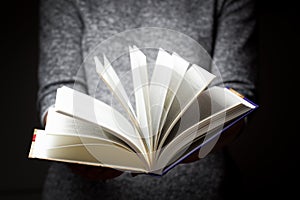 Book in woman's hands in gesture of giving