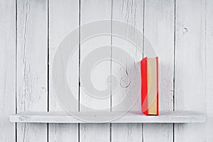 Book on a wooden shelf.