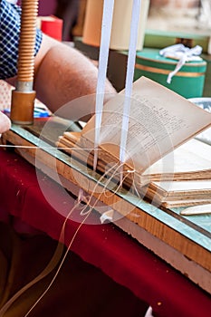 Bookbinding. Male worker binding pages.