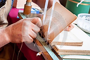 Bookbinding. Male worker binding pages.