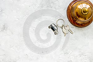 Booking hotel room, ring and keys stone desk background top view