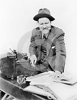 Bookkeeper with adding machine and pencil in his mouth