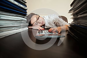 Bookkeeper asleep against big stacks of documents