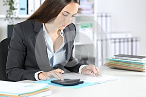 Bookkeeper calculates on calculator sitting at the office photo