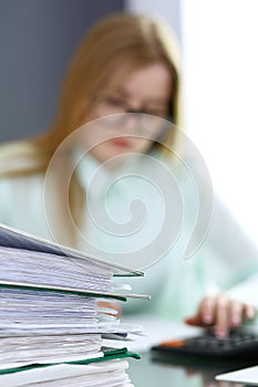 Bookkeeper or financial inspector making report, calculating or checking balance. Binders with papers closeup. Audit an