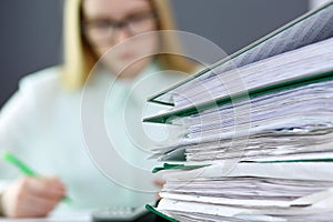 Bookkeeper or financial inspector making report, calculating or checking balance. Binders with papers closeup. Audit an