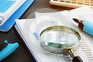 Bookkeeping and audit. Magnifying glass and business documents.