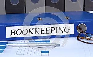 Bookkeeping - blue binder with text in the office