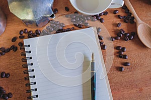 Booknote and pen on tabe with fresh coffee