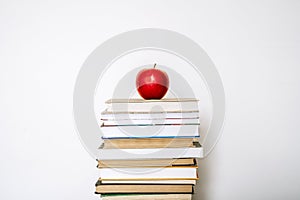 Books and an apple on a desk in a school or university classroom. Education, study concept background