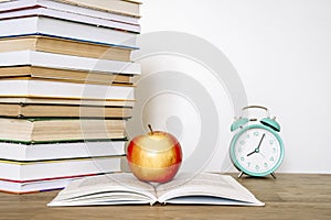 Books and an apple on a desk in a school or university classroom. Education, study concept background