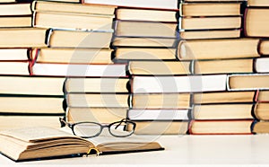 Books background, open book and glasses on white wooden table in office business background for education learning concept