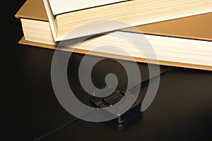 Books and a black folder on the table