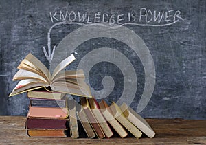 Books and blackboard with slogan knowledge  is power,learning,education,personal development and back to school concept