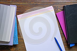 Books and blank paper sheets on table. Copy space