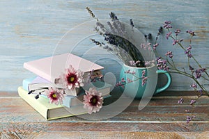 Books with bookmarks of fresh flowers, lavender bouquet on wooden table