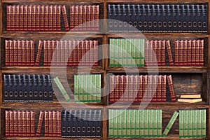 Books on the bookshelves in the library. Dark wood bookcase