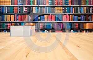 Books with copy space - text here, on a wooden deck table on a library background.