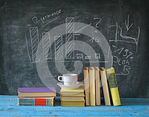 Books, cup of coffee, blackboard, diagram