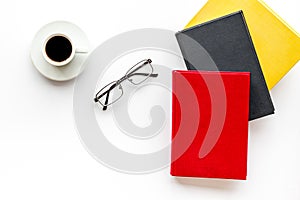 Books with empty cover near glasses, coffee on white desk background top view mockup