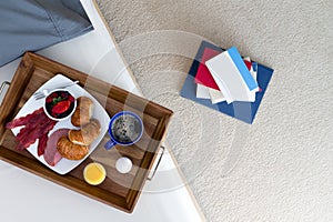 Books on Floor Beside Bed with Breakfast Tray