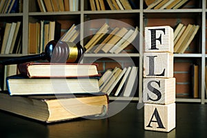 Books, gavel and cubes with FLSA or Fair Labor Standards Act.