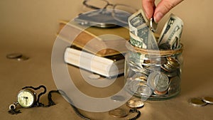 Books with glass penny jar filled with coins and banknotes. Tuition or education financing concept. Scholarship money.