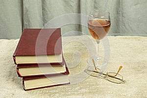 Books, a glass of wine and glasses.