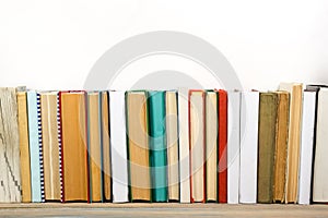 Books on grunge wooden table desk shelf in library. Back to school background with copy space for your ad text. Old