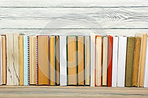 Books on grunge wooden table desk shelf in library. Back to school background, copy space for your ad text. Old hardback