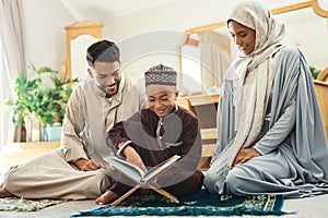 Books let you travel without moving your feet. a young muslim couple and their son reading in the lounge at home.