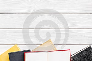 Books on library desk for reading and education on white wooden background top view mockup