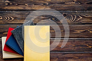 Books on library desk for reading and education on wooden background top view mockup