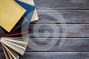 Books on library desk for reading and education on wooden background top view mockup