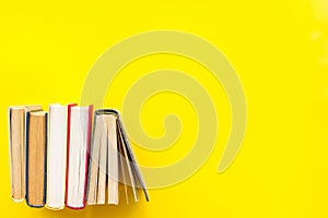 Books on library desk for reading and education on yellow background top view mockup