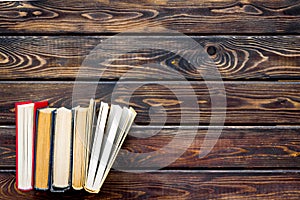 Books on library desk on wooden background top view space for text