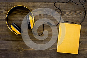 Books online concept, audiobooks. Spend leasure time reading and listening music. Headphones connected with hardback