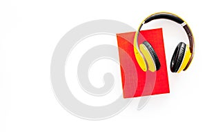 Books online concept, audiobooks. Spend leasure time reading and listening music. Headphones near hardback book with