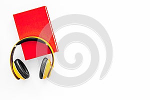 Books online concept, audiobooks. Spend leasure time reading and listening music. Headphones near hardback book with
