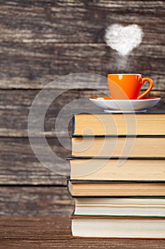 Books pile and cup of coffee with heart shape