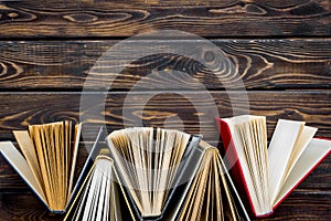 Books for reading on wooden background top view copy space